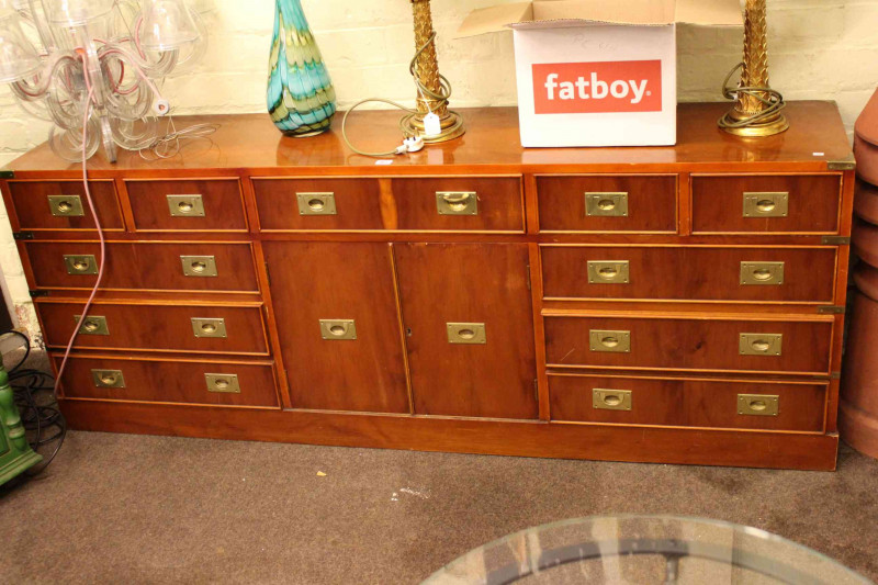 Yew campaign chest having four short and seven long drawers with two central cupboard doors, 68cm by 180cm.
